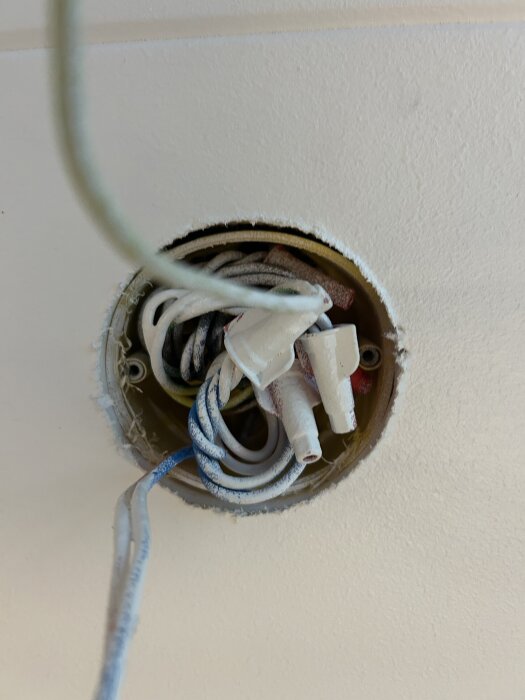 Rund takdosa med synliga kablar och skruvhål, avståndet mellan hålen är ca 7 cm, förberedd för montering av lampa.