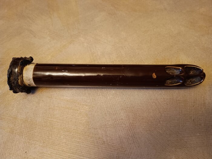 Ett kraftigt porslinsrör användes som isolator för gamla luftledningar, 35 cm långt, liggande på en ljus yta.