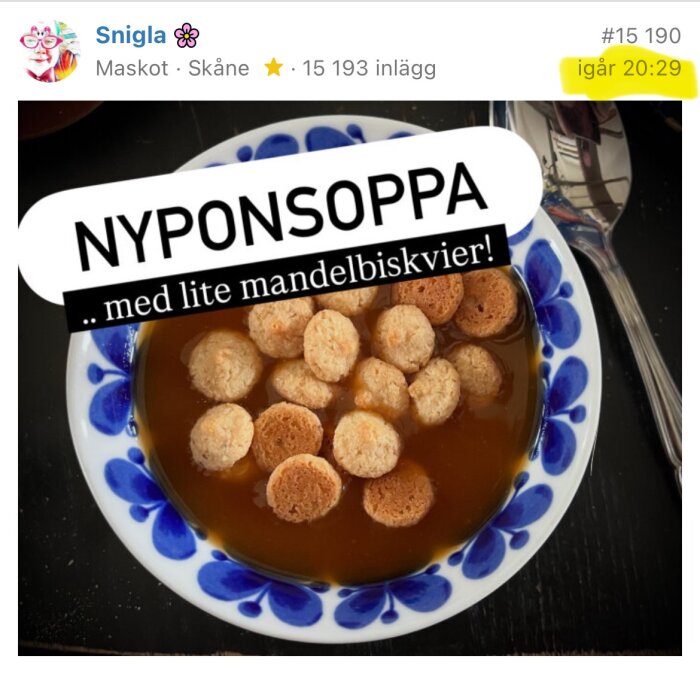 En skål med nyponsoppa och mandelbiskvier på ett bord.