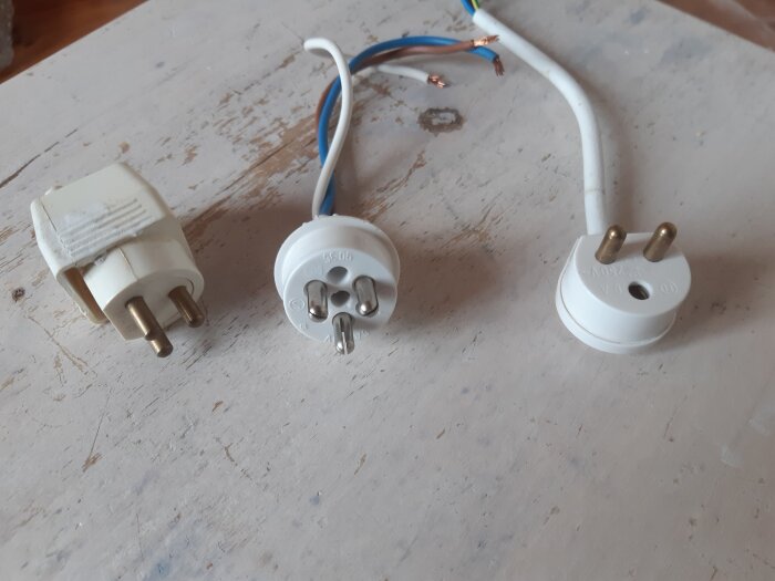 Tre olika eluttag; från vänster två äldre modeller, till höger en modernare med två stift utan jordkontakt.