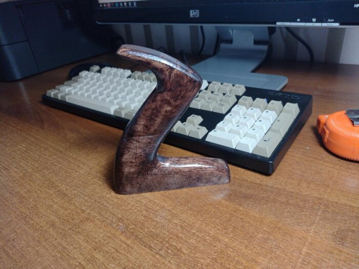 Handtag färgat med bets bredvid ett tangentbord och ett måttband.