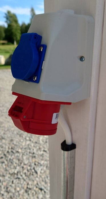 Eluttag monterat på vägg med egen 50mm PETG hållare för elrör, mekaniskt skydd och skyddslock för kablage, med kabel ansluten.