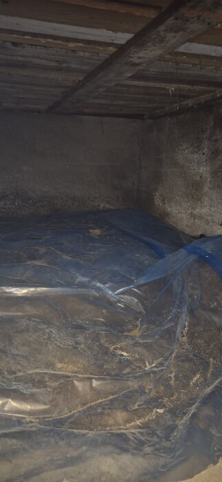 Grund med plastskikt på marken i en mörk källare.