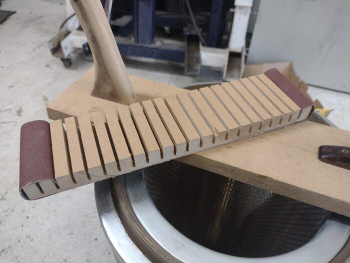 Slipblock med fastlimmat sandpapper och rundat trähandtag.