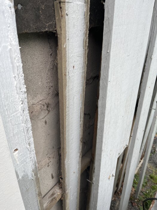 Öppen väggkonstruktion med synligt trä och betong; fråga om isolering eller luftspalt.