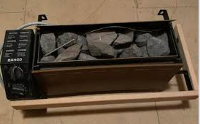 Bastuaggregat med stenar i hållare på trästödram.