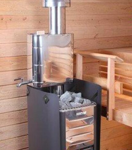 Vedeldad bastuugn med rör och vattenbehållare i träinredning.