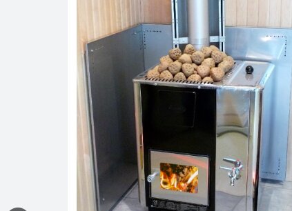 Bastuugn med vedeldning, rökrör och stenar ovanpå, tappkran på sidan.