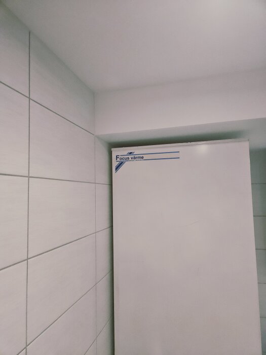 Gammal vattenvärmare i ett kaklat utrymme.