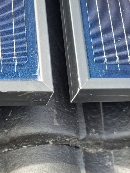 Närbild av hörnen på två solpaneler som visar repor och en springa mellan takpannorna vilken potentiellt kan leda till läckage.