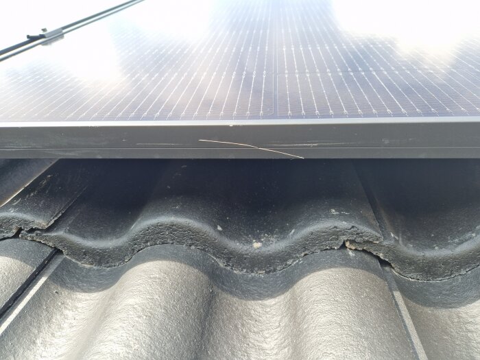 Repad solpanel på tak med betongpannor som har springor, potentiell risk för läckage.