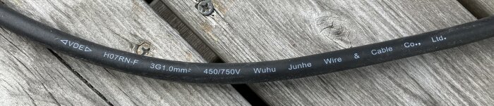 Elkabel på träpanel märkt med "H07RN-F 3G1.0mm² 450/750V Wuhu Junhe Wire & Cable Co., Ltd.