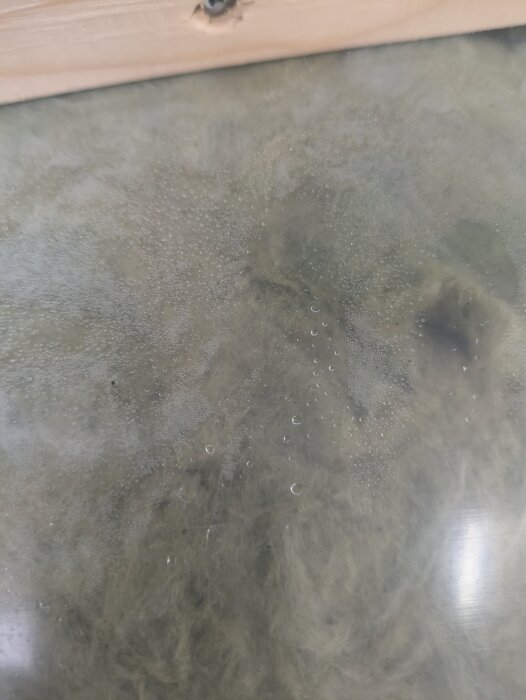 Kondensdroppar syns på en isoleringsskiva av skalmur, vilket diskuteras i fråga om lämplighet för isolering av ovanvåning.