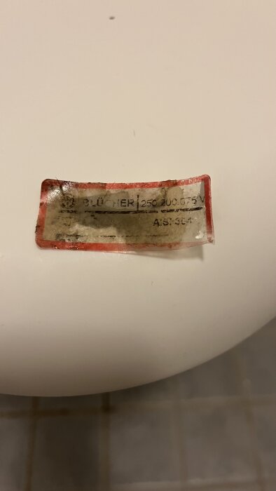 Smutsig märkning med texten "BLÜCHER 250.200.075V" på en vit yta.