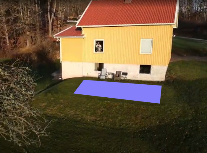Gul villa med rött tak, ljusblå rektangel på gräsmattan, symboliserar planerad poolplats. Man med hund syns i ett fönster.