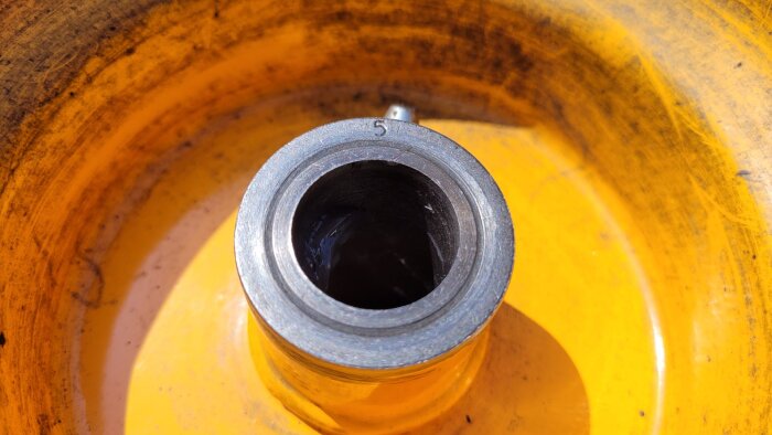 Närbild på ett hjullager i en gul fälg, med siffran 5 synlig på lagrets kant.