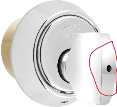 Vred på dörrlås med hål för eventuell insexskruv, markerad med röd linje.