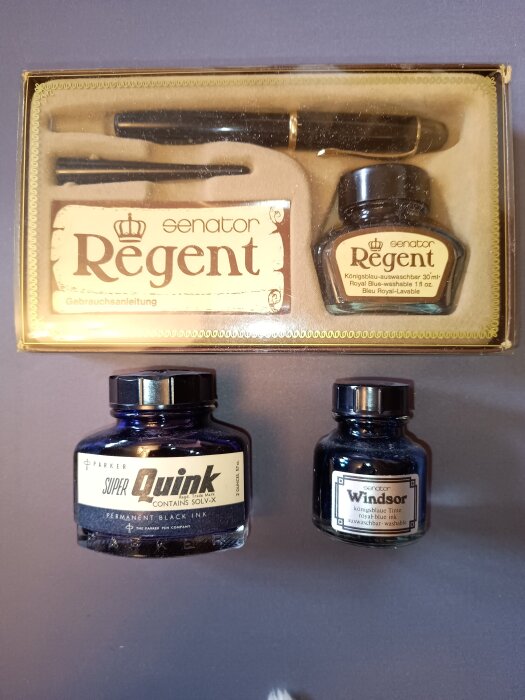 Bläckset: Senator Regent bläckpenna med tillbehör, Parker Super Quink svart bläckflaska och Windsor blå tvättbar bläckflaska på en slät yta.
