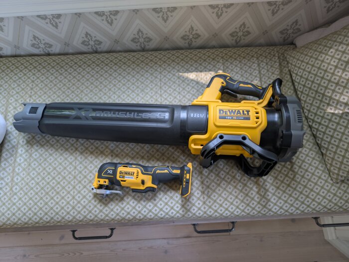 Elektrisk lövblås och multiverktyg från Dewalt, placerade på en mönstrad bäddsoffa, köpta på Prime Day.