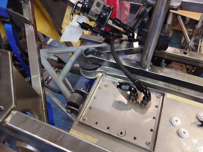 Metallkonstruktion med rör, kablar och ett papper märkt "5".