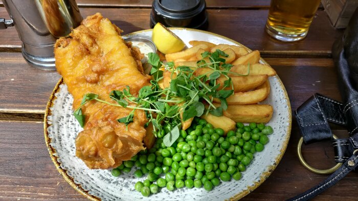 Tallrik med fish and chips, gröna ärtor och citron på The George Inn, London.