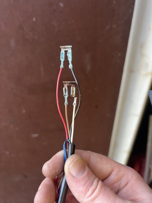 Tre kablar med metallkontakter visas. Kablarna används för byte av glödlampa i nummerskyltsbelysning.