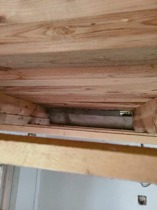 Träkonstruktion med luftspalt mellan reglar, där en ventilationslösning övervägs.