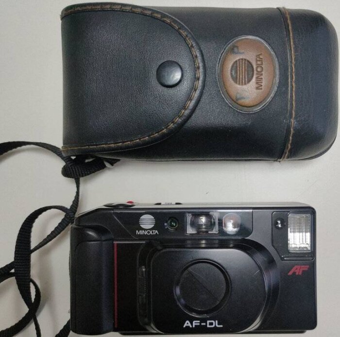 Minolta kompaktkamera AF-DL med svart kameraväska, populär innan digitalkameror blev vanliga, från diskussion om fotografins utveckling.