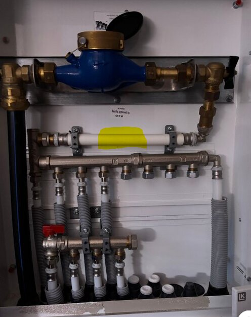 Rörinstallation med kulventiler, en del är markerad i gult för att indikera plats för ny kulventil med handtaget utåt; blå komponent syns högst upp.