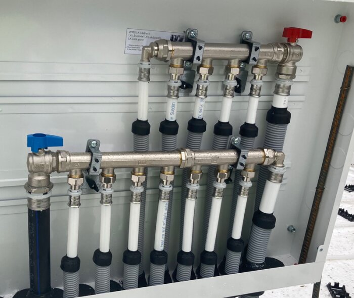 LK-skåp med rörkopplingar och ventiler, använd som referens för installation.