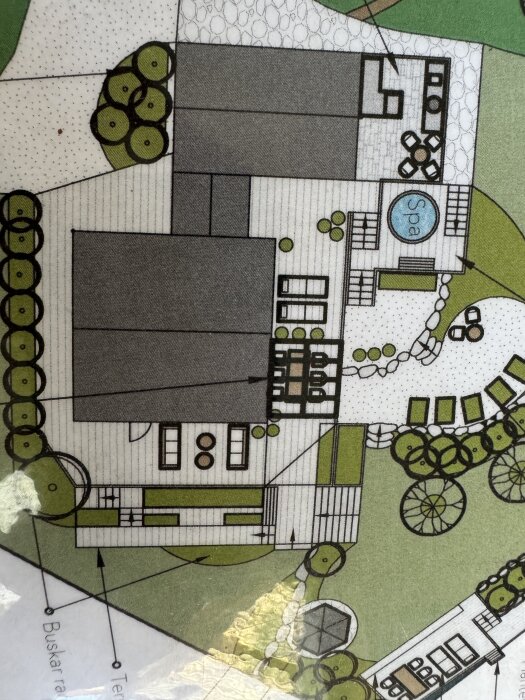 Arkitektskiss av en tomt med rektangulära byggnader, en spa-avdelning och snedväggslösning; omgivna av växtlighet och gångvägar.