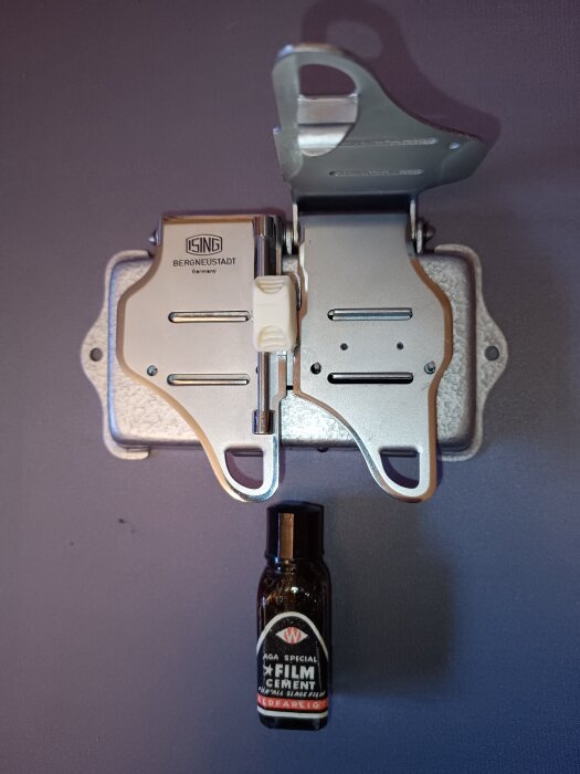 Skarvapparat och flaska filmcement för smalfilmsredigering, märkt "K.W. Special Film Cement".