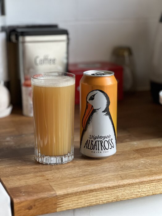 Ett glas ljus öl bredvid en burk märkt "Stigbergets Albatross" NEIPA, placerad på en köksbänk.