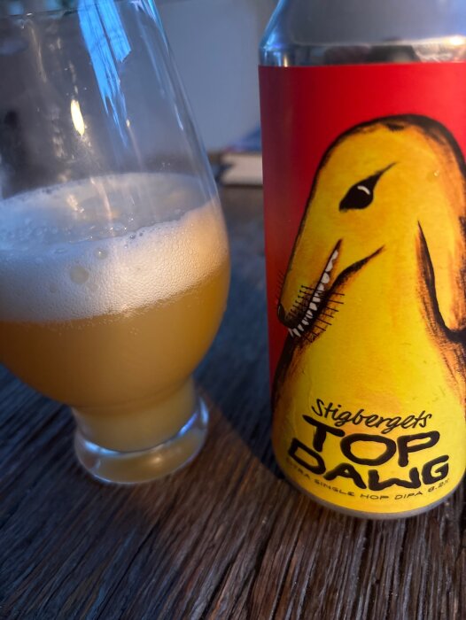 Stigbergets Top Dawg ölburk och ett glas öl på ett bord.