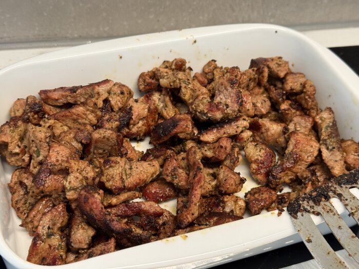 Hemlagad kebabkött i en vit ugnsform, del av en hemgjord kebabrulle.