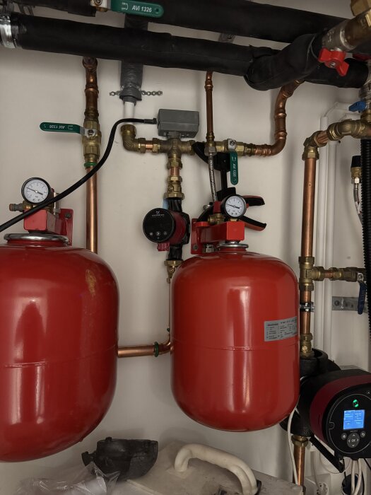 Två röda tryckkärl anslutna till rör i ett frikylesystem, förberedda för installation.