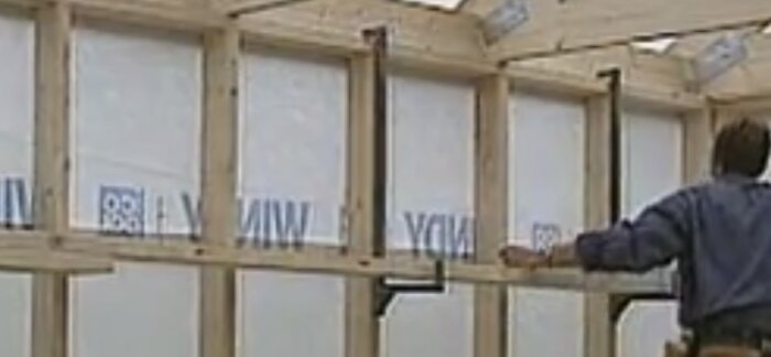 Byggkonsoler fästa vid regelstomme med arbetande person.