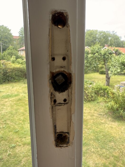 Fönsterkarm med två stora hål för fästning, ett upptill och ett nedtill, och två små hål i mitten; behöver möjligtvis nya hål.