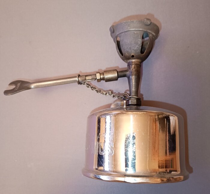 En liten enmans bensinkök utan rörliga delar, med stegeformad brännare och en förvaringsask som stöd för kokkärl.