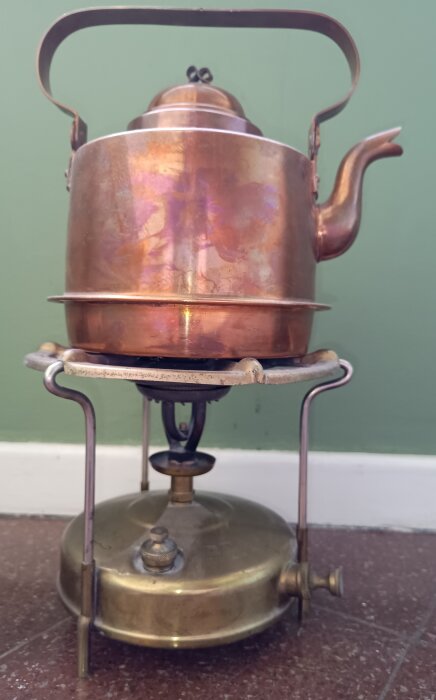 Fotogeneldat kök modell Prince No 95 från K F Eriksson, Eskilstuna, med koppardetaljer och arabisk text, stående mot en grön bakgrund.