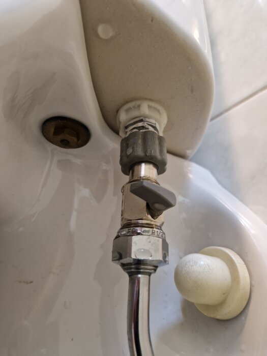 Ingående vattenkoppling med avstängningsventil till en Gustavsbergs vägghängd toalett, visar rör och ventil som orsakar läckage.