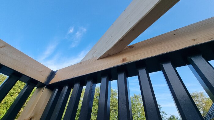 Prefabricerade takstolar som precis monterats på plats under en klarblå himmel.