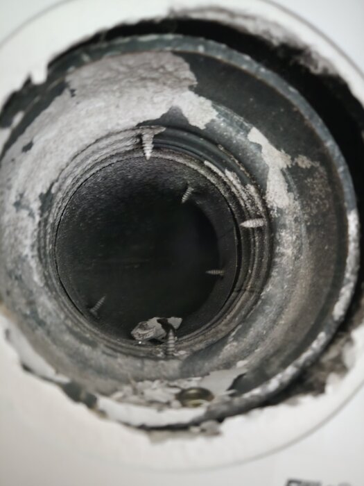 Tillluftsuttag med synliga skruvar och färgflagor i ett rum där en garderobsvägg ska byggas.