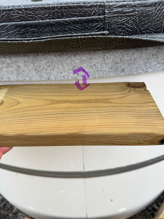 Träplanka mäter avståndet mellan altan och bad, med fokus på potentiell sänkning och rörelse.