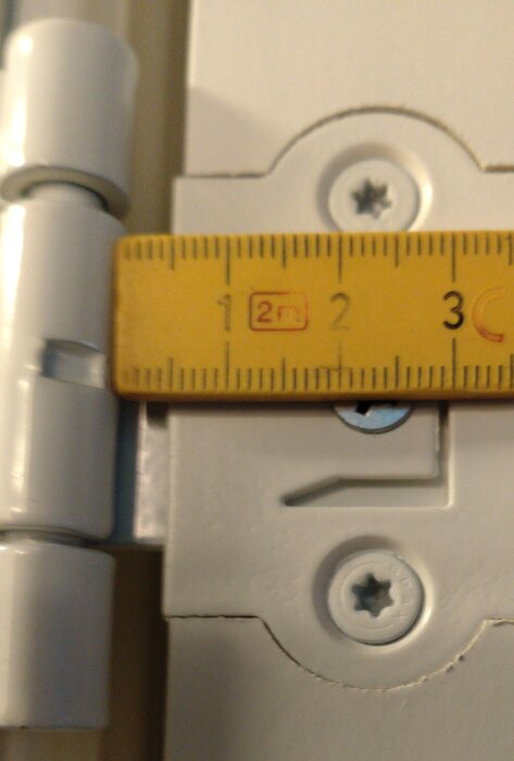 Mätsticka visar avstånd på 4 mm mellan snap-in gångjärn och dörrdel, två skruvar synliga, ett monteringsfel diskuteras.