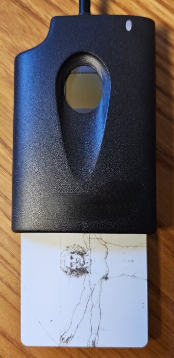 90-tals kortläsare med fingertryckskontroll, serieportanslutning och kort med teckning av mänsklig figur.