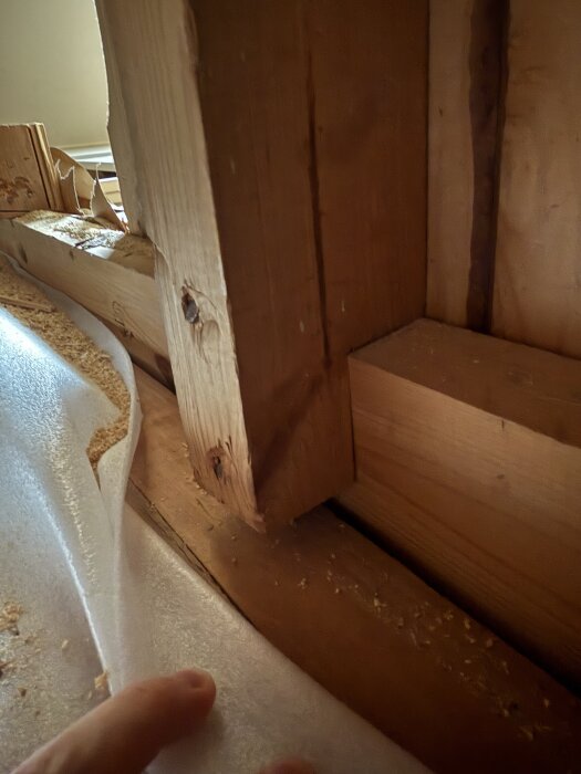 Trävägg med vertikala och horisontella reglar, där de vertikala är rödmarkerade och de horisontella gulmarkerade, i en 60-tals villa.