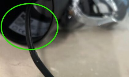 Klisterlapp inuti en mörkfärgad kopp med synlig text och ett kabel.