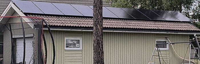 Garage med 10 solpaneler monterade på taket, färdig på ena sidan.