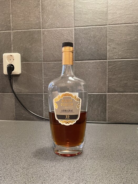 En flaska Olivier Gessler Armagnac XO på en grå köksbänk mot en kaklad vägg.